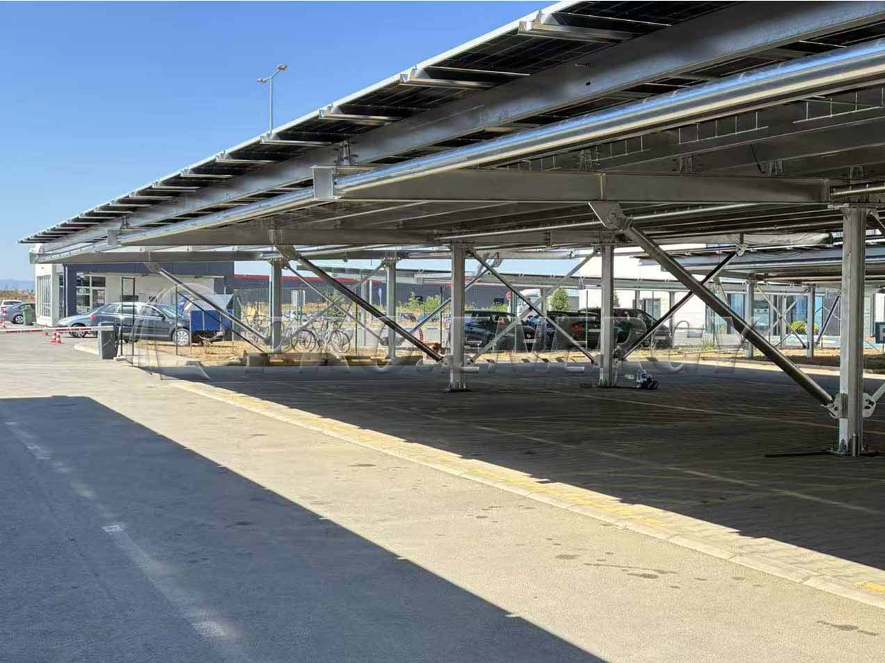 PROFENCE.ENERGY 11‑meter wide‑span carbon steel solar carport mounting system on project site, large parking solar canopy structure
